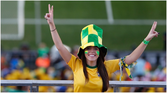 A woman poses for a photograph flashing V-for-victory signs before the World Cup opening match between Brazil and Croatia at Itaquerao Stadium in Sao Paulo, Brazil, Thursday, June 12, 2014. Thursday is a holiday in Sao Paulo and everybody is celebrating the start of the international soccer tournament. Fans dressed in yellow and green greeted each other, often yelling, "Vai Brazil!" 
