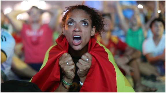 Wrapped in a Spanish national flag, a soccer fan reacts in frustration as she watches the live broadcast of the World Cup match between Spain and the Netherlands inside the FIFA Fan Fest area on Copacabana beach in Rio de Janeiro, Brazil, Friday, June 13, 2014. The Netherlands thrashed Spain 5-1 Friday. It was a humiliating defeat for the defending World Cup champions. 